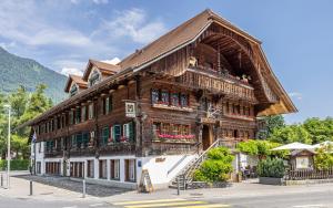 a large wooden building with a gambrel roof at Hotel Restaurant Hirschen in Interlaken