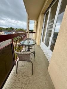 a balcony with a glass table and chairs on it at Appartement moderne tout équipé in Évreux