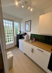 a kitchen with a sink and a microwave at Appartement moderne tout équipé in Évreux