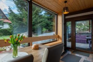 a dining room with a table and a large window at Chalet Dereše in Liptovský Mikuláš
