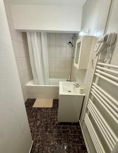 a bathroom with a sink and a tub and a toilet at Appartement moderne tout équipé in Évreux +17 photos