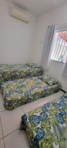 a room with two beds sitting on the floor at Casa de praia em Guriri in Guriri
