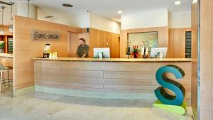 a man standing at a bar in a restaurant at Sercotel Porta Barcelona in Sant Just Desvern