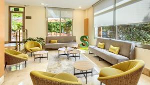 a lobby with couches and chairs and tables at Sercotel Porta Barcelona in Sant Just Desvern