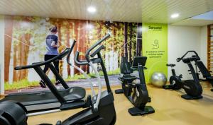 a woman in a gym with cardio machines at Sercotel Porta Barcelona in Sant Just Desvern