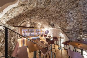 a restaurant with a stone wall and tables and chairs at Hotel Restaurant Hirschen in Interlaken