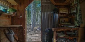 an open door to a kitchen in a cabin at Rustic Cabin on Off-Grid Homestead in Brattfors