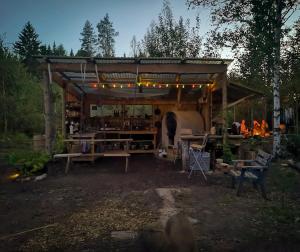 a wooden shed with a table and a grill at Rustic Cabin on Off-Grid Homestead in Brattfors