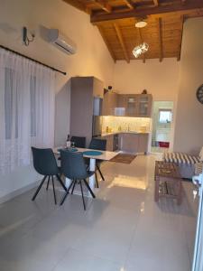 a living room with a table and chairs and a kitchen at apartment Himara SkyView in Himare