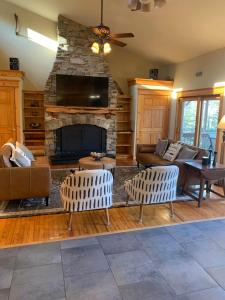 a living room with a couch and a fireplace at Private Lakefront with Dock! in Bethel