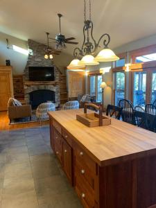 a kitchen and living room with a stone fireplace at Private Lakefront with Dock! in Bethel