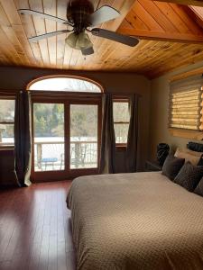 a bedroom with a ceiling fan and a bed at Private Lakefront with Dock! in Bethel +8 photos