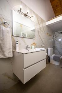 a white bathroom with a sink and a mirror at Αριάδνη in Archanes +19 photos