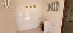 a bathroom with white walls and a sink at Casa de praia em Guriri in Guriri +49 photos