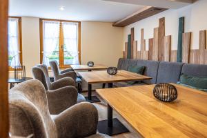 a waiting room with couches and tables and chairs at Hotel Restaurant Hirschen in Interlaken