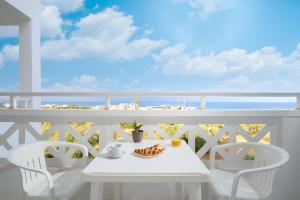 a white table and chairs on a balcony with the ocean at Nikolas Villas Appartments in Hersonissos