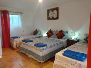 a bedroom with three beds in a room at cabañas Te Pito Kura in Hanga Roa