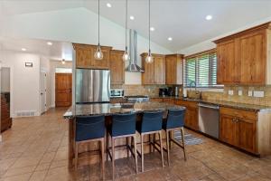 a kitchen with wooden cabinets and blue bar stools at Piney Ridge TR6 Hot Tub Pool in Eden