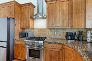 a kitchen with wooden cabinets and a stove top oven at Piney Ridge TR6 Hot Tub Pool in Eden +32 photos