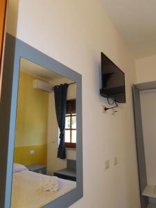 a mirror in a room with a bed and a television at B&B Casa Lamanna in Torretta