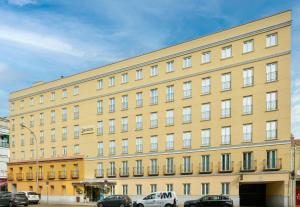 a large yellow building with cars parked in front of it at Sercotel Alcalá 611 in Madrid +27 photos