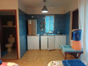 a kitchen with blue tiled walls and white cabinets at cabañas Te Pito Kura in Hanga Roa +51 photos