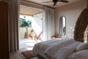 a bedroom with a bed and a sliding glass door at Proyecto Palmita in El Pescadero