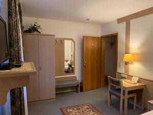 a hotel room with a mirror and a chair and a room at Zum Flößer in Neckartenzlingen