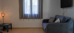 a living room with a blue couch and a television at Ionian Casa Azul in Karavomylos