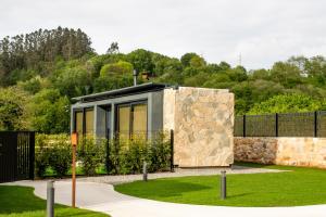 a modern house with a stone wall at LA TIERRUCA HOMES in Barcenaciones