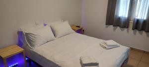 a bed with white sheets and pillows in a room at Ionian Casa Azul in Karavomylos