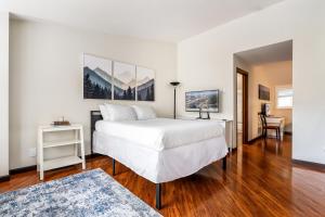 a bedroom with a large white bed and a table at Seasons Alpine Retreat in Avon