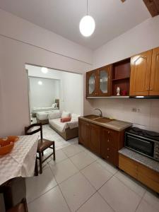 a kitchen and living room with a table and a couch at City Center Hotel in Sarandë