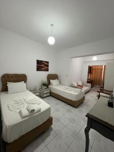 a bedroom with two beds and a living room at City Center Hotel in Sarandë