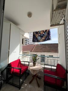 a balcony with two red chairs and a table at City Center Hotel in Sarandë