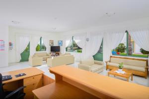 a large living room with white furniture and windows at Nikolas Villas Appartments in Hersonissos