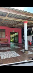 a red building with a bench and a pillar at Studio Khalida Taman Perdana in Pekan