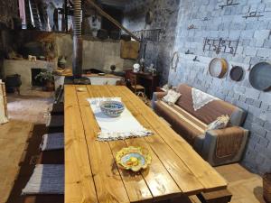 a wooden table in a room with a couch at Villa Etna Masi' in Milo