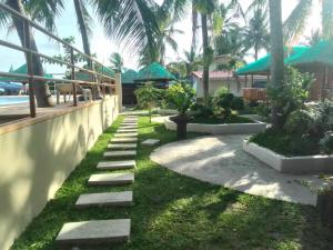 a pathway leading to a resort with palm trees at Balai-Cintai Beach Resort in Castañas