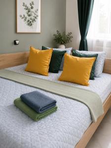 a large bed with yellow and blue pillows on it at Powidz Comfort Suites in Powidz +12 photos