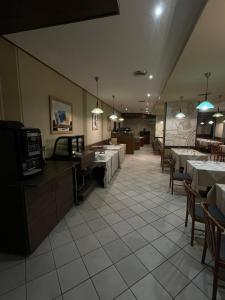 ein Speisesaal mit Tischen und Stühlen und ein Restaurant in der Unterkunft Hotel Tre Denti in Cantalupa