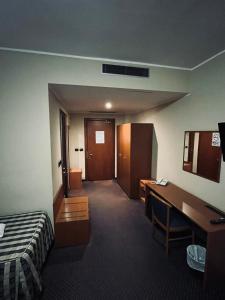 ein Hotelzimmer mit einem Schlafzimmer mit Schreibtisch und Bett in der Unterkunft Hotel Tre Denti in Cantalupa