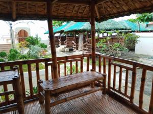 a wooden porch with a bench on a deck at Balai-Cintai Beach Resort in Castañas