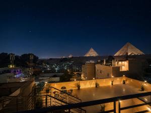 a view of the pyramids from a building at night at Dima Plaza Pyramids View in Cairo +68 photos