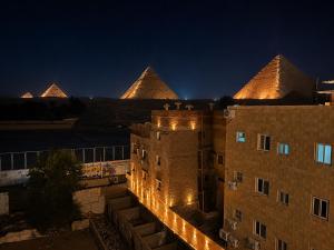 a view of a building with pyramids in the background at Dima Plaza Pyramids View in Cairo