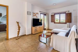 a living room with a couch and a tv at Can Rusiniol 2 in Puig D’en Valls