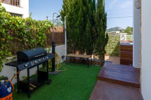 a backyard with a grill and green grass at Can Rusiniol 2 in Puig D’en Valls