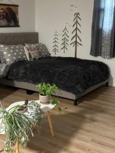 a bedroom with a bed and a table with plants at Cabin Experience near all in Wilkes-Barre