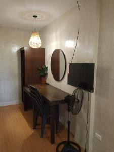 a dining room table with a television and a mirror at Balai-Cintai Beach Resort in Castañas