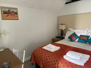a bedroom with a bed with towels on it at Artists Cottages Artists Loft near Hornbeam Park Free Parking in Harrogate +5 photos